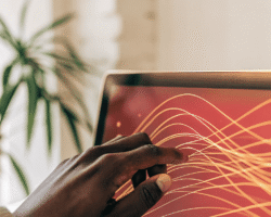 A human hand interacting with a glowing, holographic screen displaying abstract orange and yellow data visualizations, symbolizing human guidance over AI in financial decision-making.