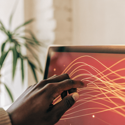 A human hand interacting with a glowing, holographic screen displaying abstract orange and yellow data visualizations, symbolizing human guidance over AI in financial decision-making.